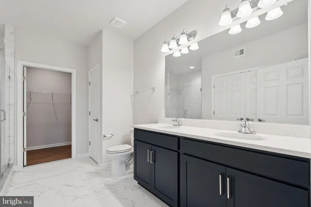 a spacious bathroom with a double vanity sink mirror and toilet