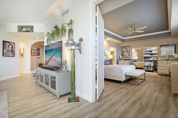 a bedroom with a large bed a chandelier and couches