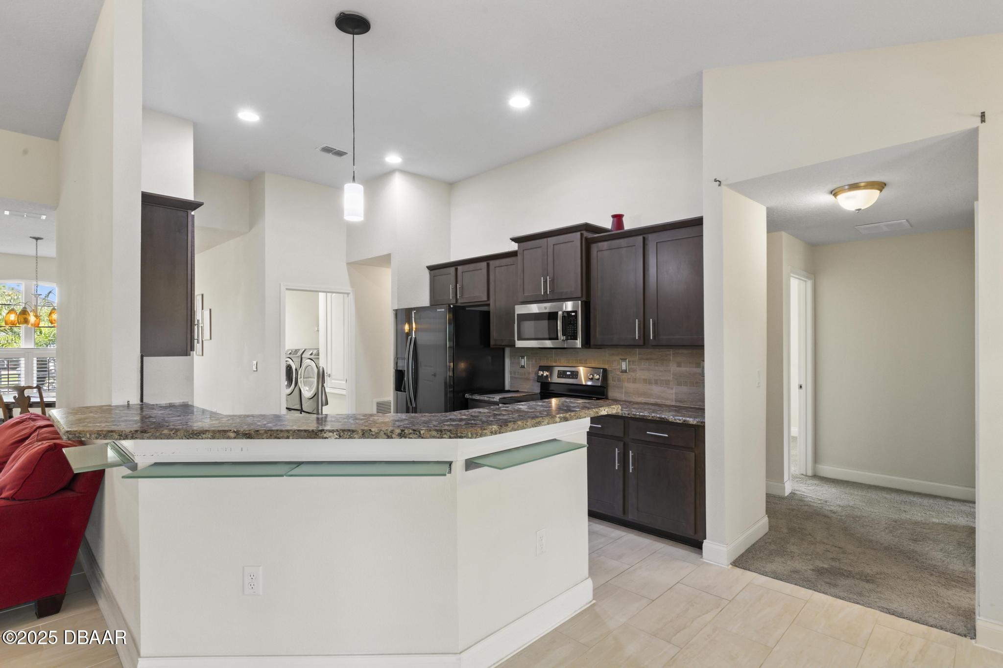 66 Eagle Lake Drive Flagler Beach, FL 32136 - Photo 17 of 77 a kitchen with kitchen island granite countertop stainless steel appliances a sink stove and refrigerator