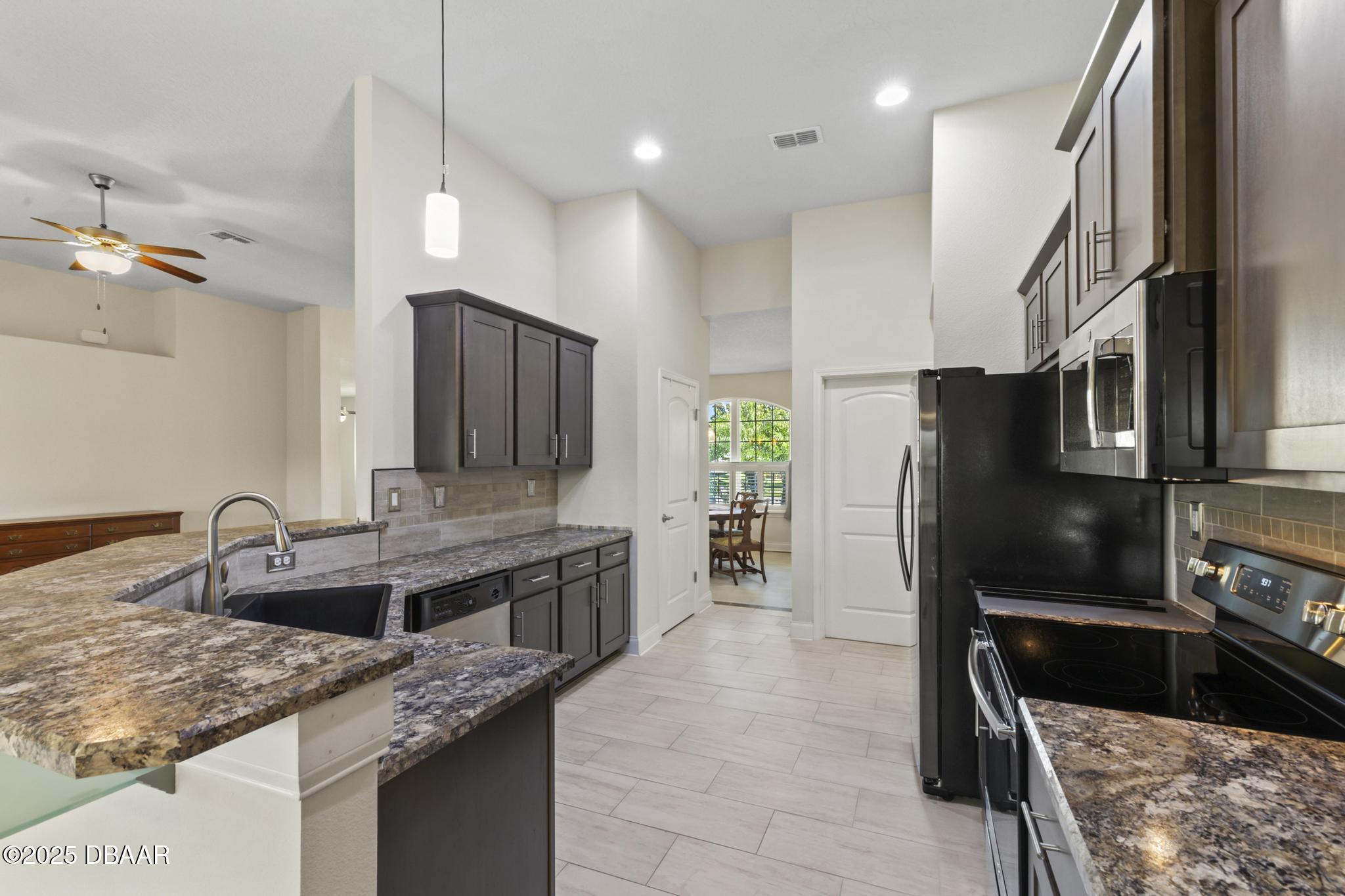 66 Eagle Lake Drive Flagler Beach, FL 32136 - Photo 18 of 77 a kitchen with stainless steel appliances granite countertop a sink and a refrigerator