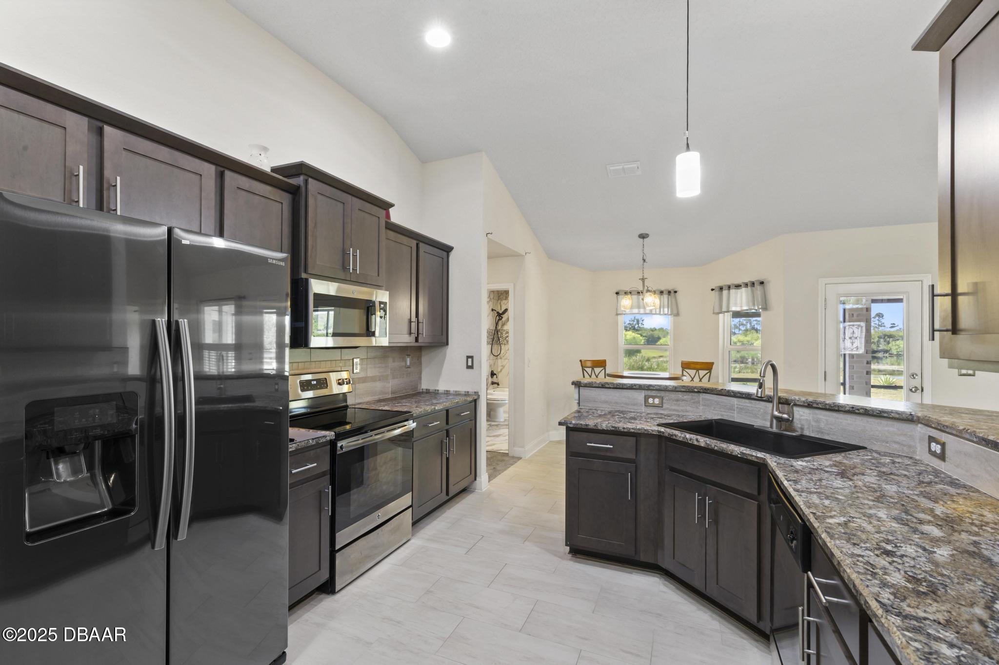 66 Eagle Lake Drive Flagler Beach, FL 32136 - Photo 19 of 77 a kitchen with stainless steel appliances granite countertop a sink stove and refrigerator