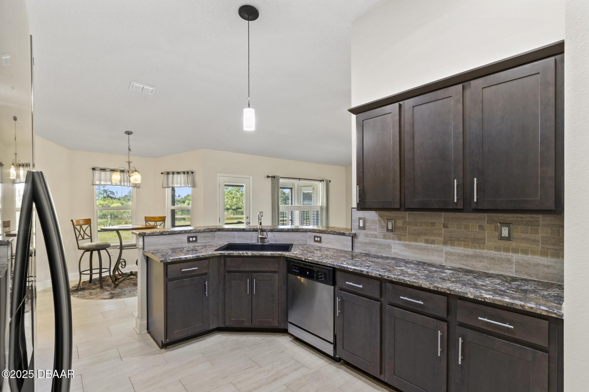 66 Eagle Lake Drive Flagler Beach, FL 32136 - Photo 20 of 77 a kitchen with a sink a stove and cabinets