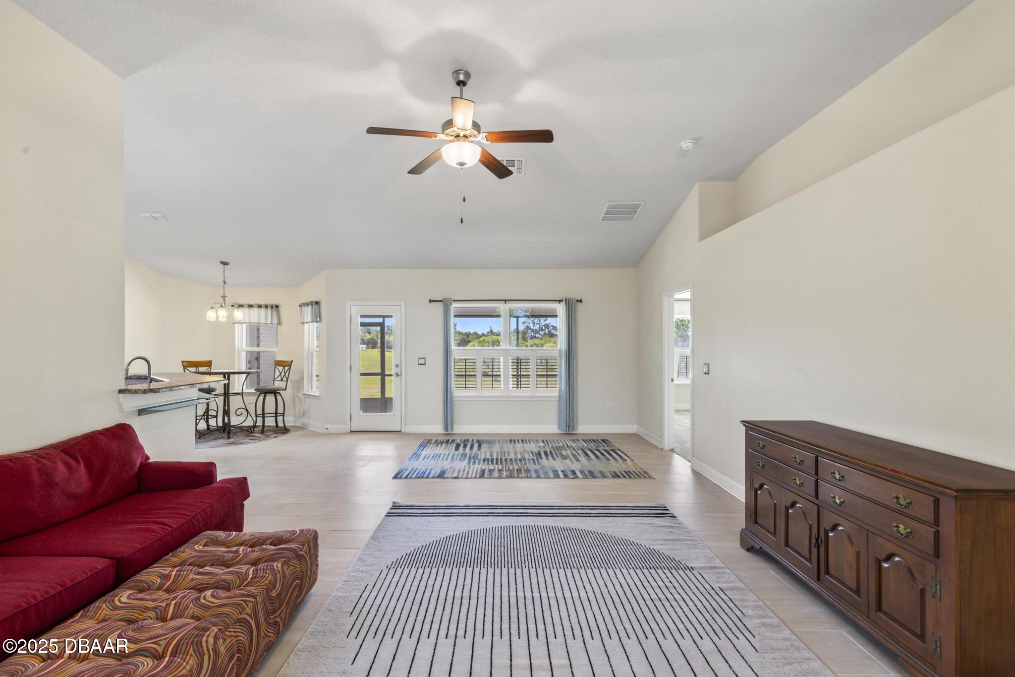 66 Eagle Lake Drive Flagler Beach, FL 32136 - Photo 2 of 77 a living room with furniture and a chandelier
