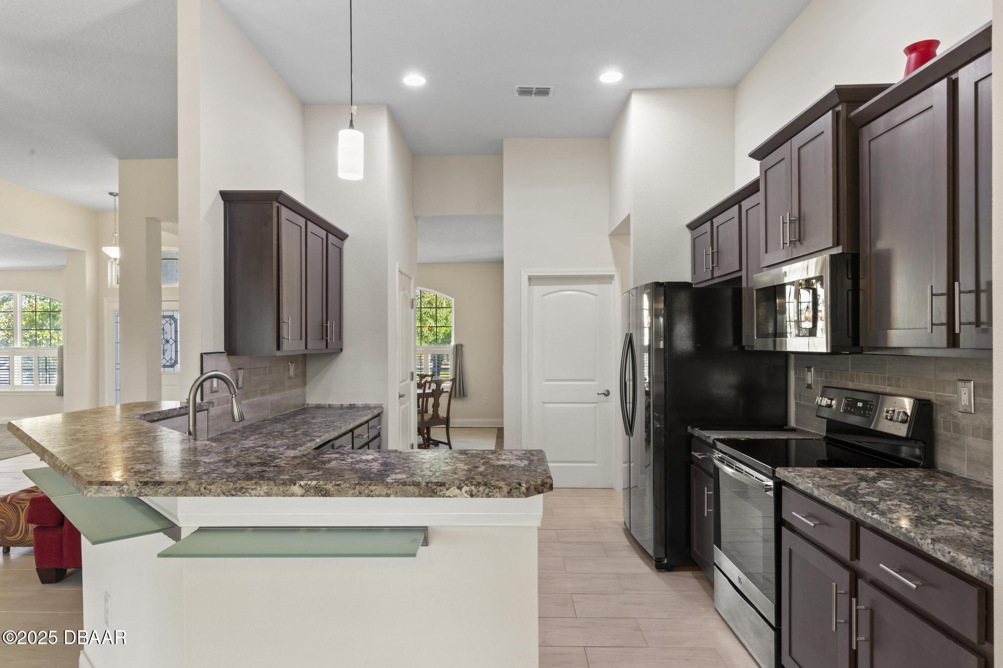 66 Eagle Lake Drive Flagler Beach, FL 32136 - Photo 3 of 77 a kitchen with stainless steel appliances granite countertop a refrigerator a stove and a sink