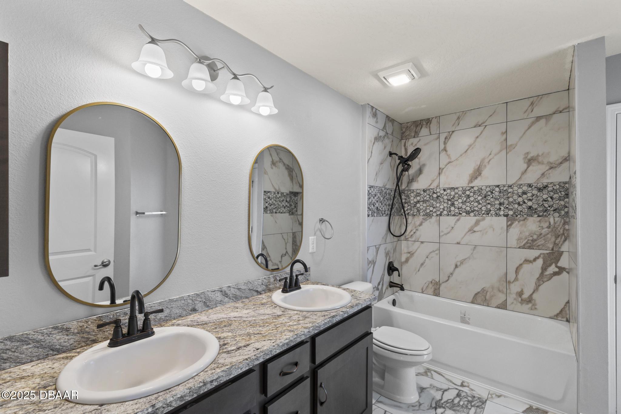 66 Eagle Lake Drive Flagler Beach, FL 32136 - Photo 41 of 77 a bathroom with a granite countertop toilet a sink and a mirror