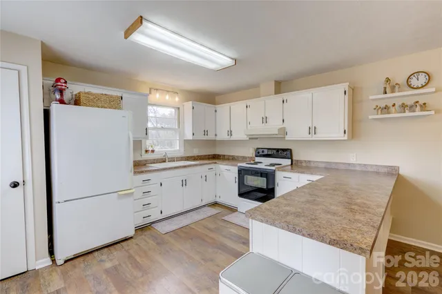 a kitchen with granite countertop white cabinets and white appliances
