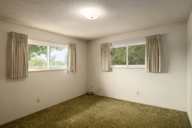an empty room with closet and a ceiling fan