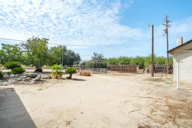 a view of back yard of the house with wooden fence