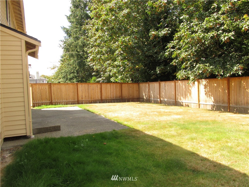 11224 Southeast 188th Place Renton, WA 98055 - Photo 2 of 16 a view of a backyard with a large tree and wooden fence