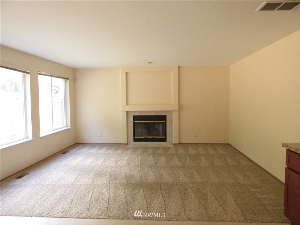 11224 Southeast 188th Place Renton, WA 98055 - Photo 8 of 16 an empty room with windows and fireplace