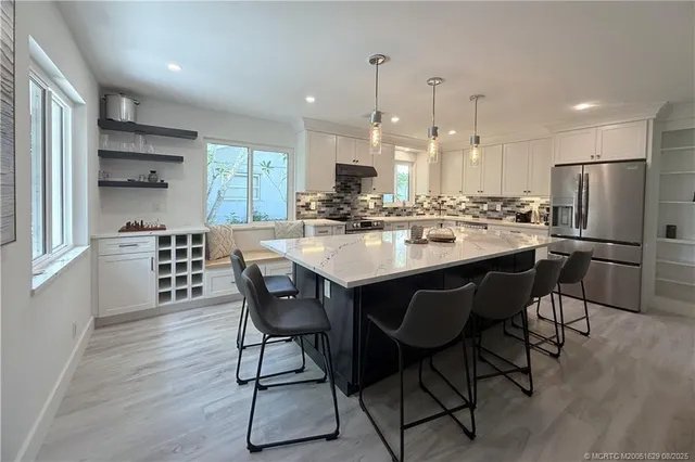a kitchen with kitchen island a dining table and chairs