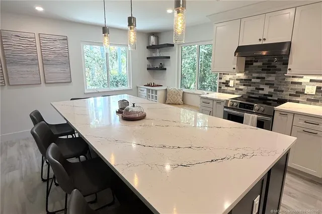 a kitchen with a stove a refrigerator and a dining table