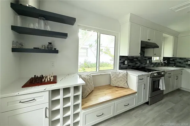 a kitchen with white cabinets and a stove top oven