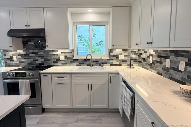 a kitchen with a sink stove and cabinets