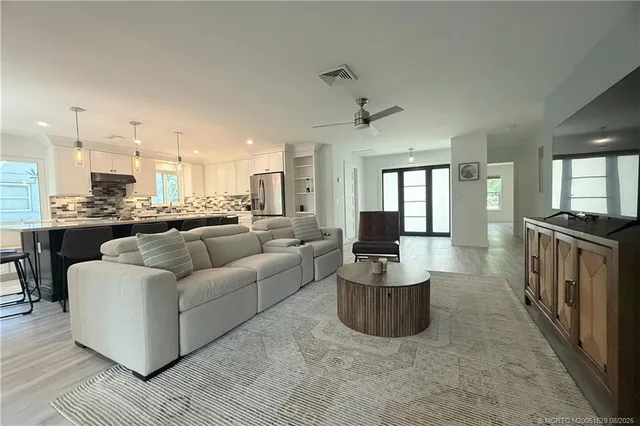 a living room with furniture and a view of kitchen