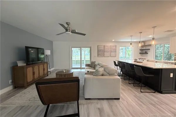 a living room with furniture flat screen tv and window