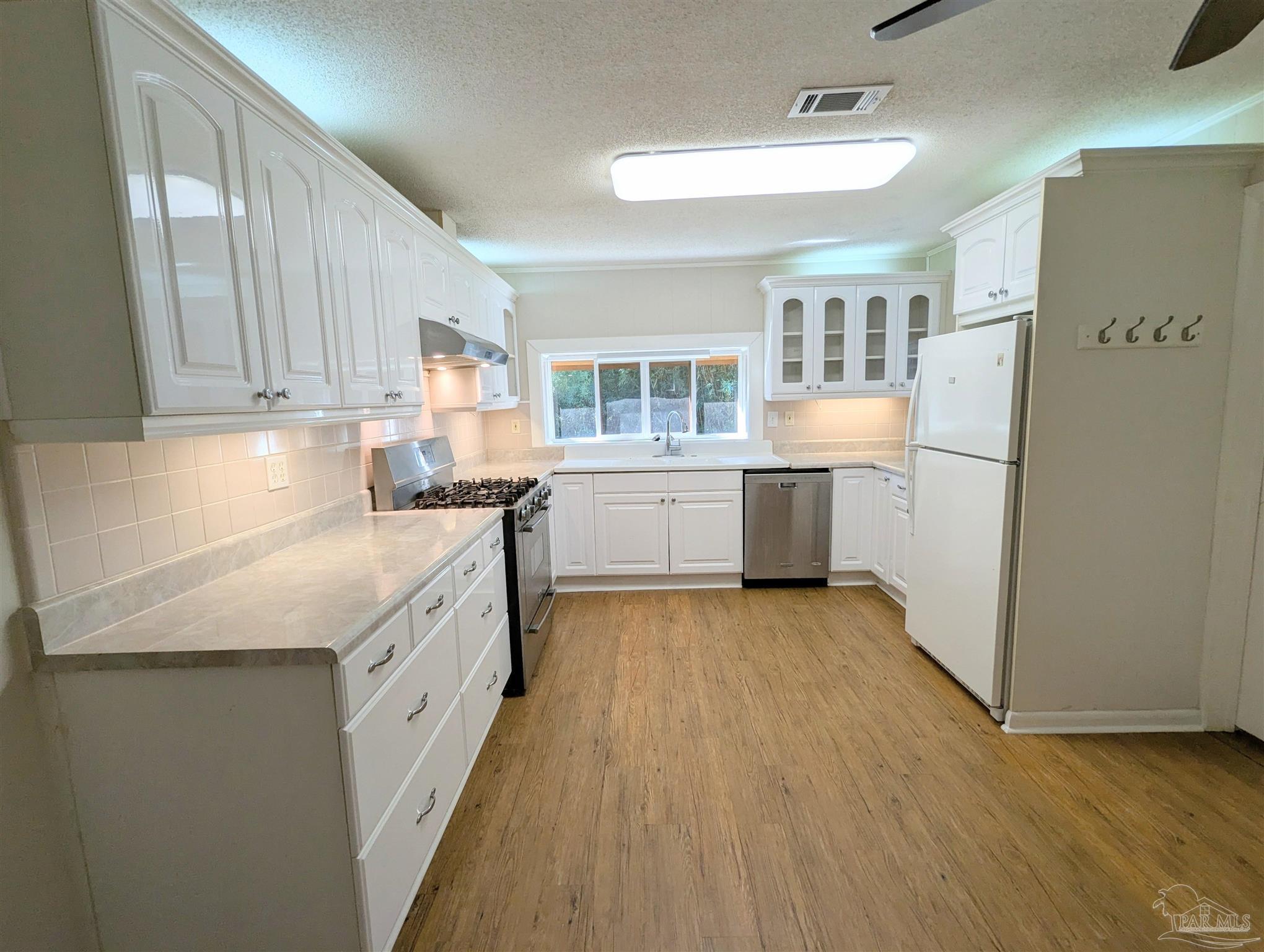 4301 Willow Street Pace, FL 32571 - Photo 12 of 25 a kitchen with stainless steel appliances granite countertop a sink stove and refrigerator