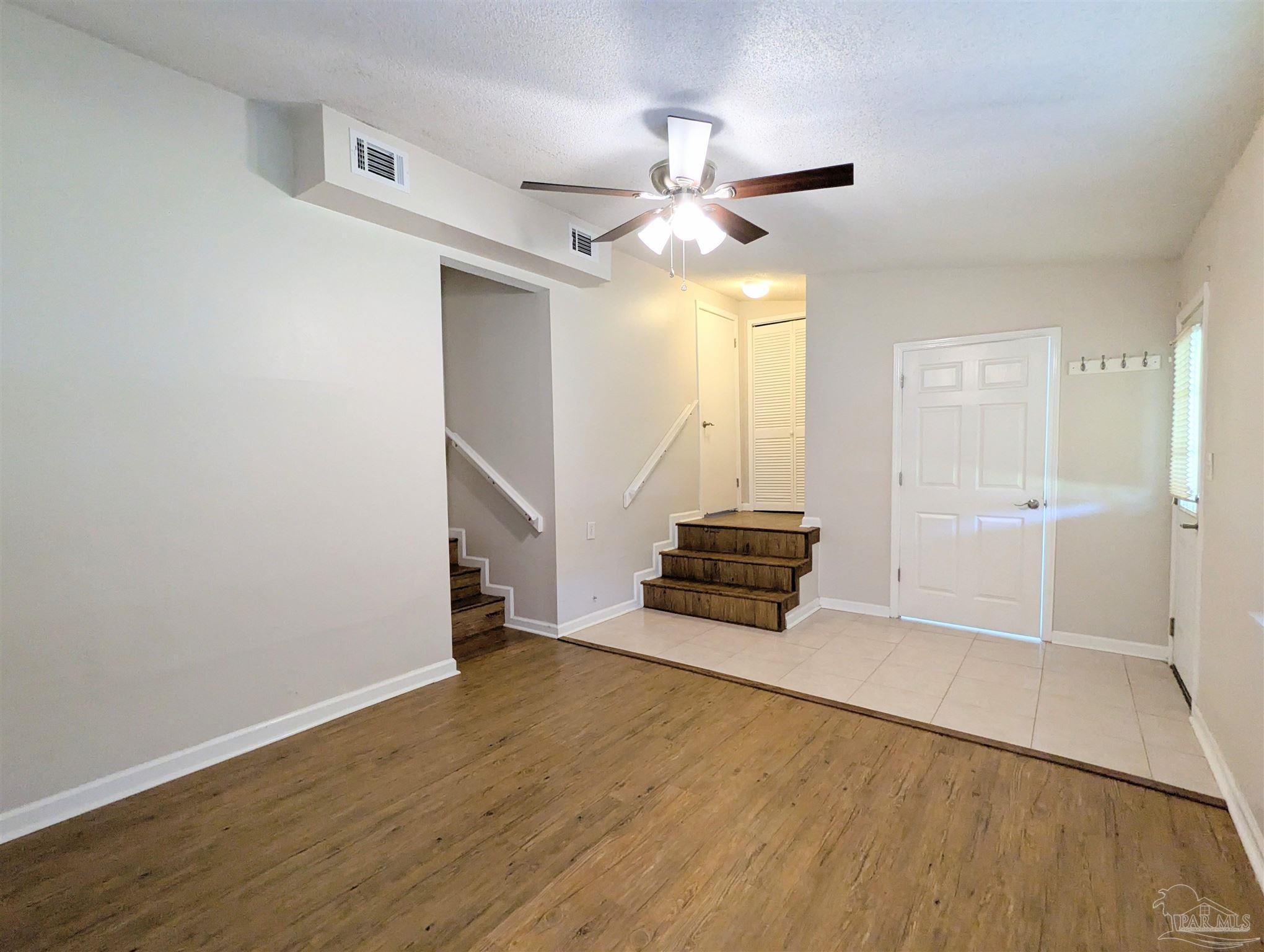 4301 Willow Street Pace, FL 32571 - Photo 16 of 25 an empty room with wooden floor fan and windows