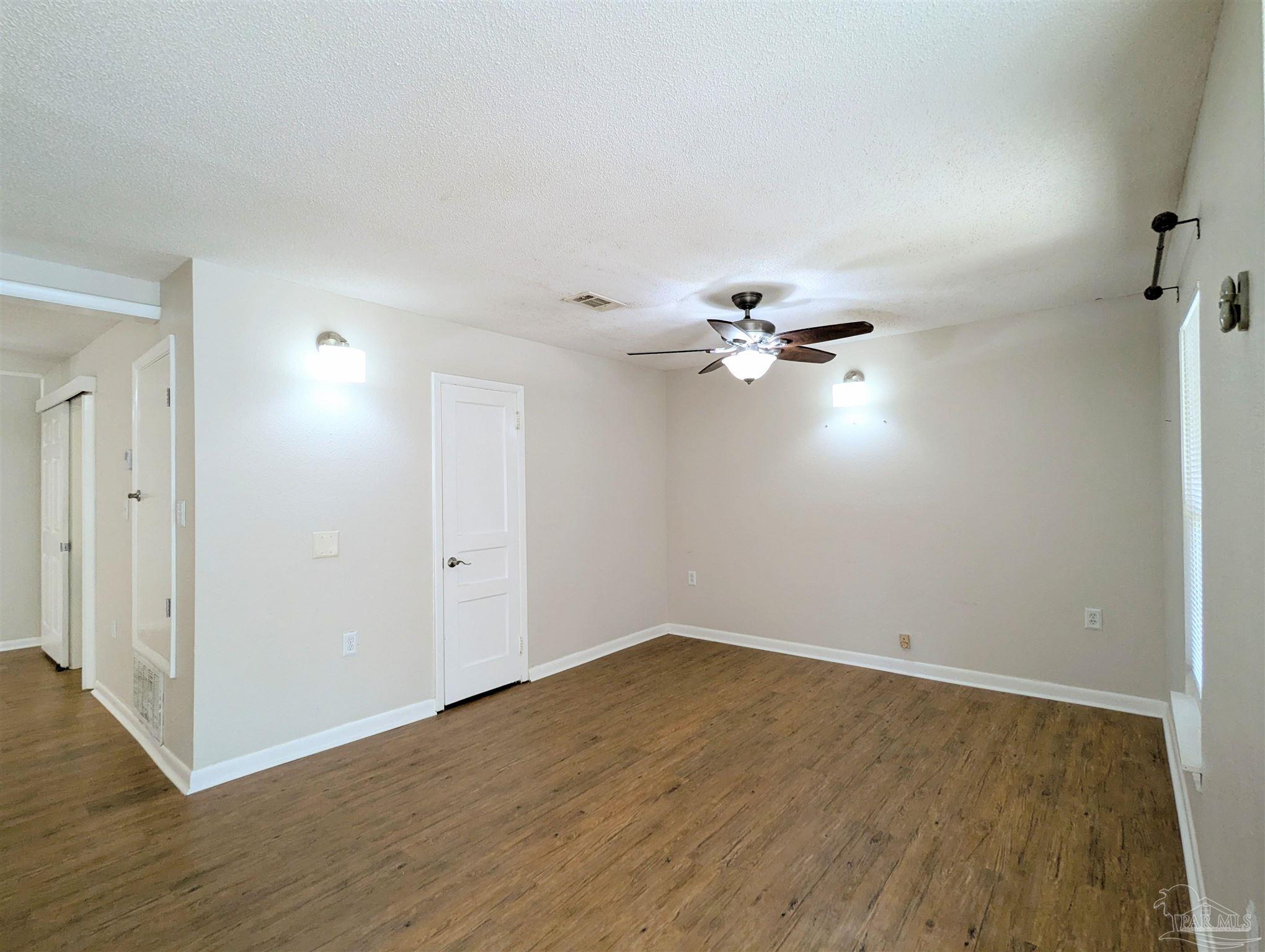 4301 Willow Street Pace, FL 32571 - Photo 3 of 25 a view of a room with wooden floor and ceiling fan