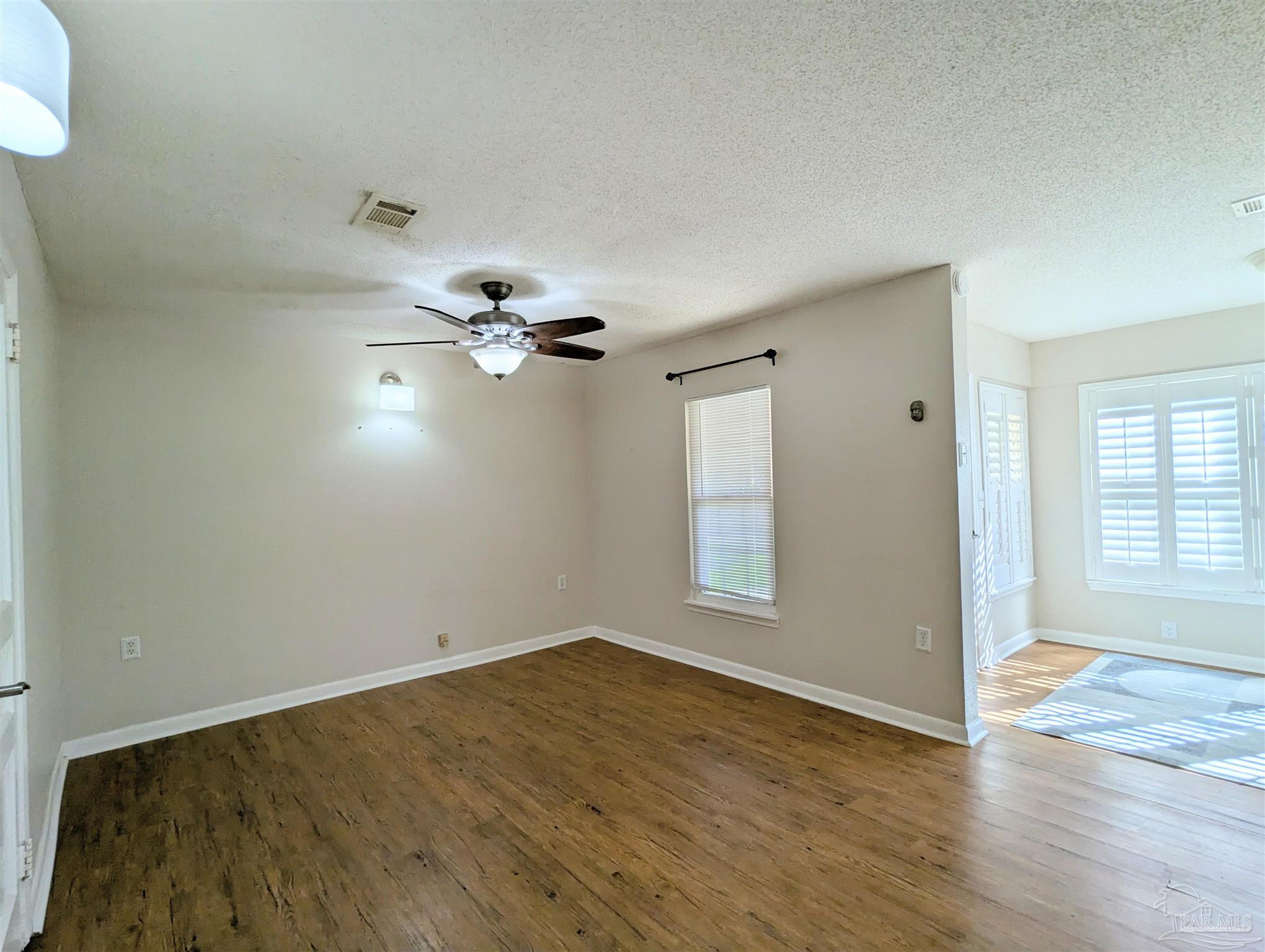 4301 Willow Street Pace, FL 32571 - Photo 4 of 25 wooden floor in an empty room with a window