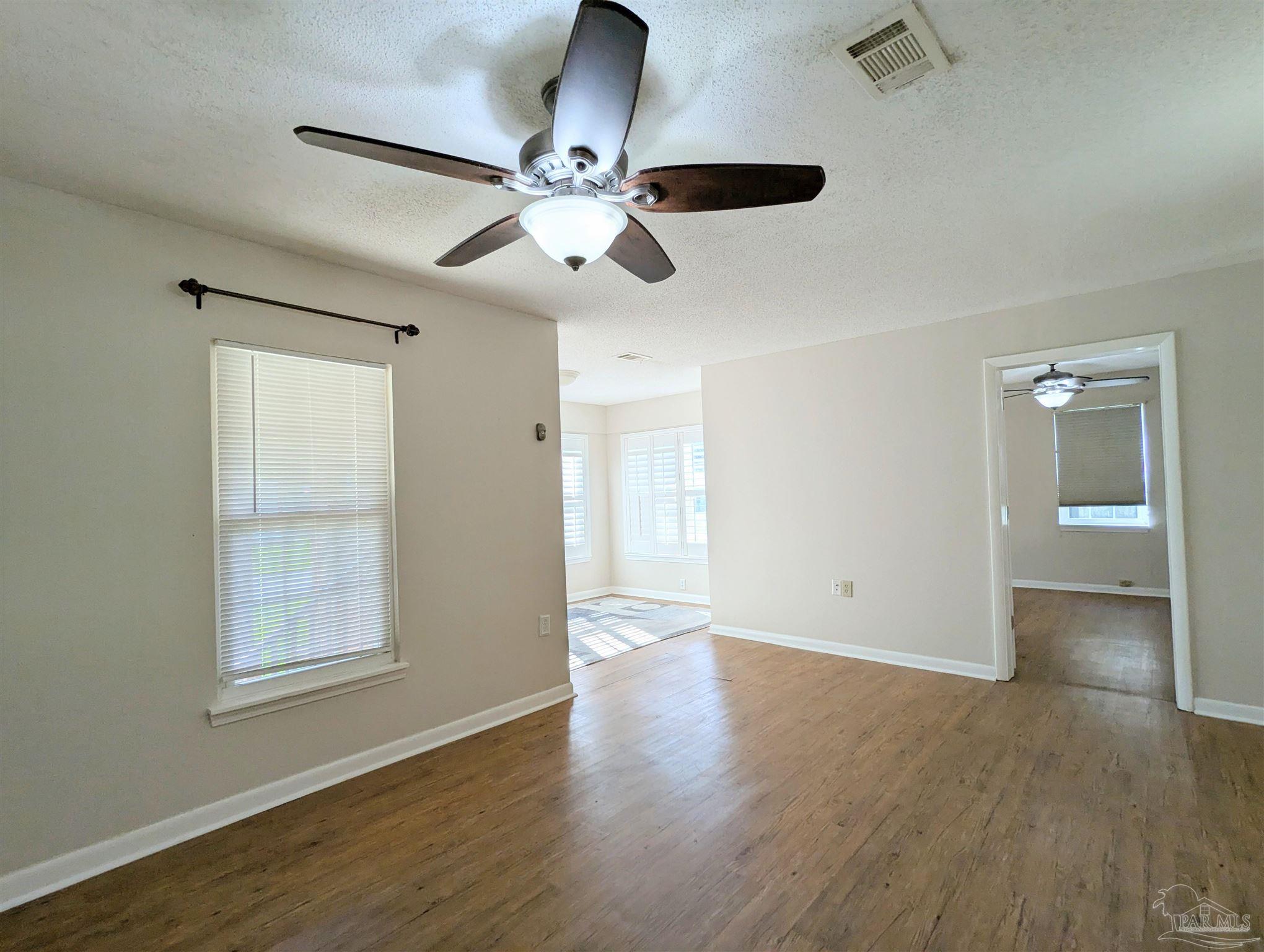 4301 Willow Street Pace, FL 32571 - Photo 5 of 25 a view of an empty room with wooden floor and a window