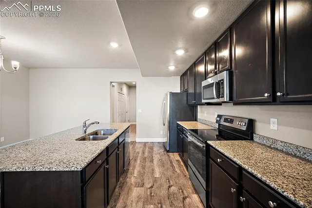 a kitchen with granite countertop stainless steel appliances and wooden cabinets
