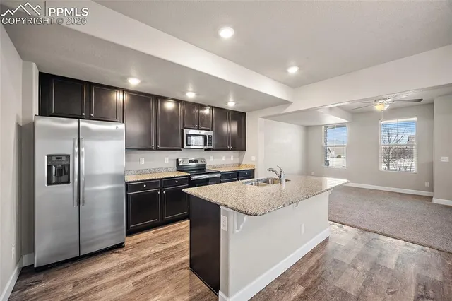 a large kitchen with stainless steel appliances granite countertop a refrigerator a sink a stove and oven