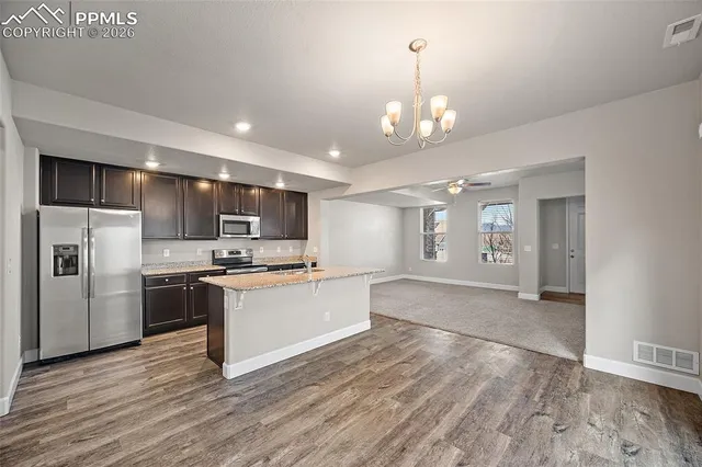 a large kitchen with kitchen island a sink stainless steel appliances and cabinets