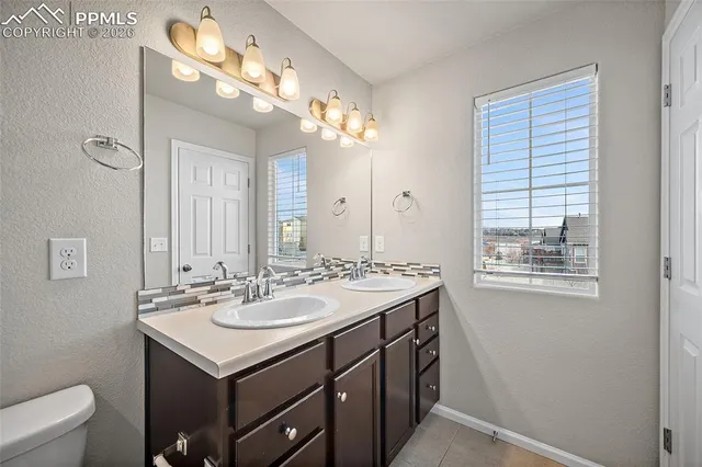 a bathroom with a double vanity sink toilet and shower