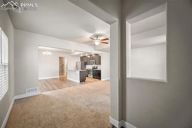 a view of a room with kitchen and windows