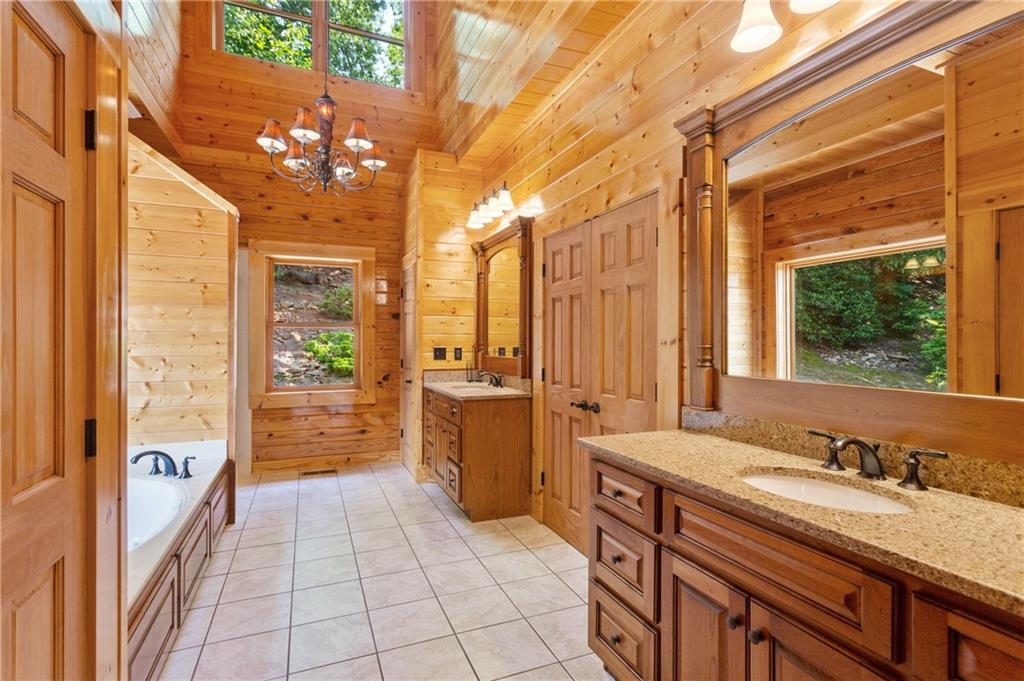 729 Huckleberry Way Jasper, GA 30143 - Photo 43 of 74 a bathroom with a granite countertop sink a toilet a mirror and shower