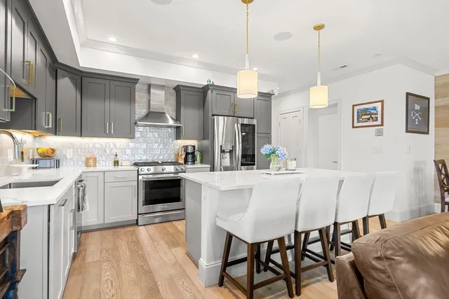 a kitchen with stainless steel appliances a dining table chairs sink and cabinets