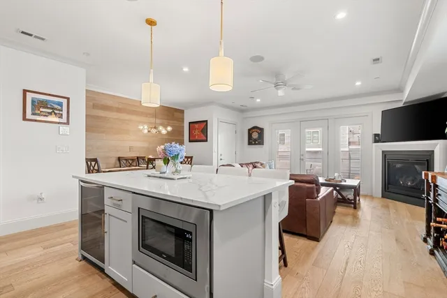 a open kitchen with stainless steel appliances granite countertop a stove and a wooden floor
