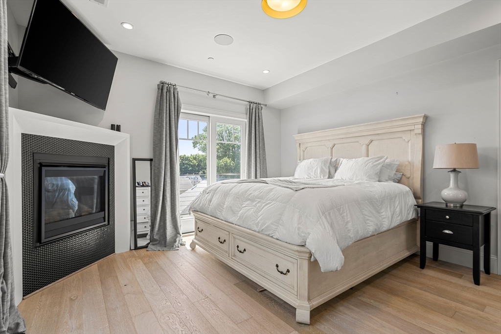 251 Minot Street, Unit 6 Boston, MA 02124 - Photo 14 of 30 a spacious bedroom with a bed and a flat screen tv