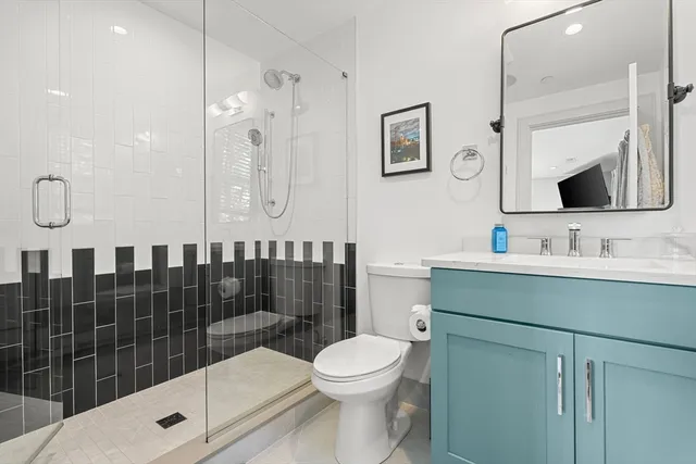 a bathroom with a sink a toilet and shower