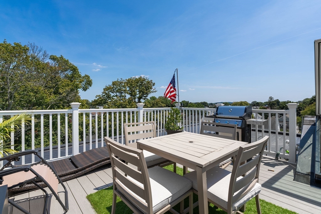 251 Minot Street, Unit 6 Boston, MA 02124 - Photo 22 of 30 a view of a dinning table and chairs on the roof deck