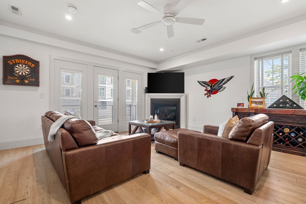 251 Minot Street, Unit 6 Boston, MA 02124 - Photo 6 of 30 a living room with furniture a fireplace and a flat screen tv