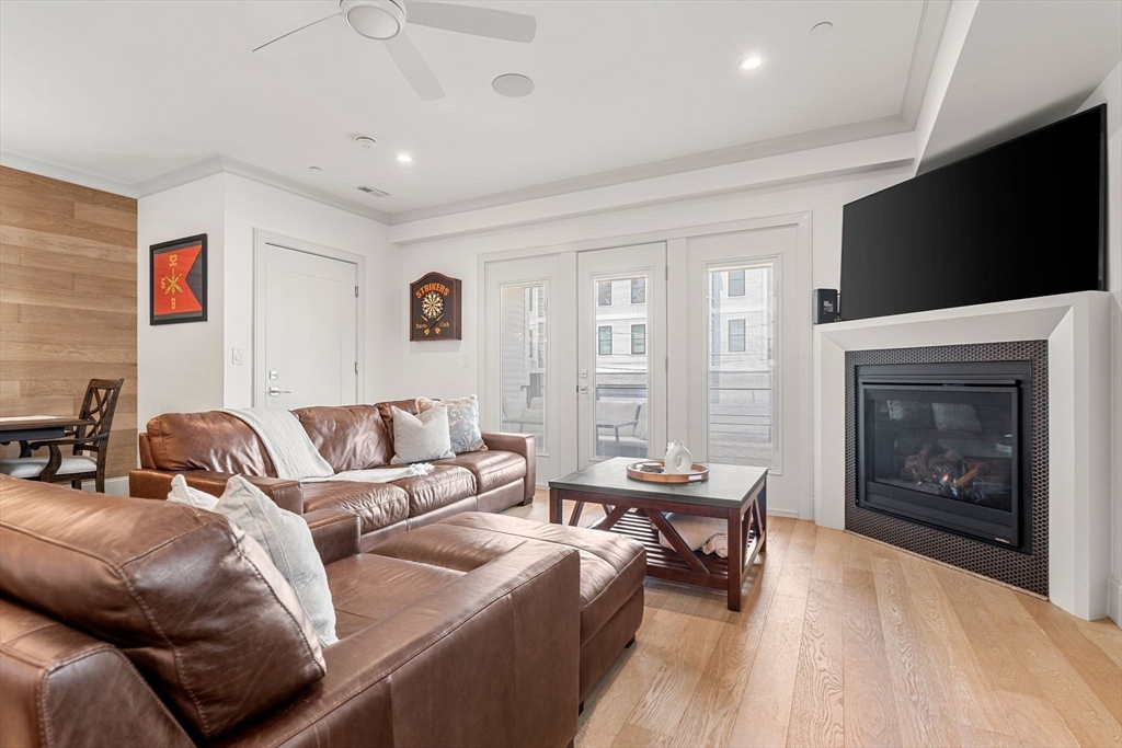 251 Minot Street, Unit 6 Boston, MA 02124 - Photo 7 of 30 a living room with furniture a fireplace and a flat screen tv