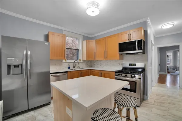 a kitchen with stainless steel appliances a stove microwave and a refrigerator