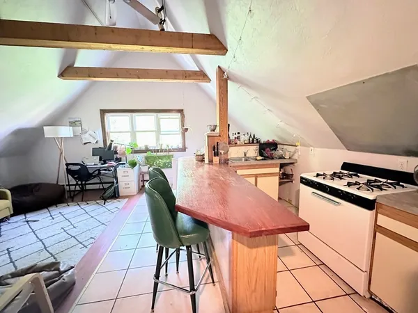 a kitchen with stainless steel appliances a stove a sink and a dining table