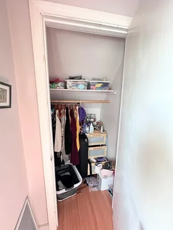 a view of walk in closet with clothes and shoes