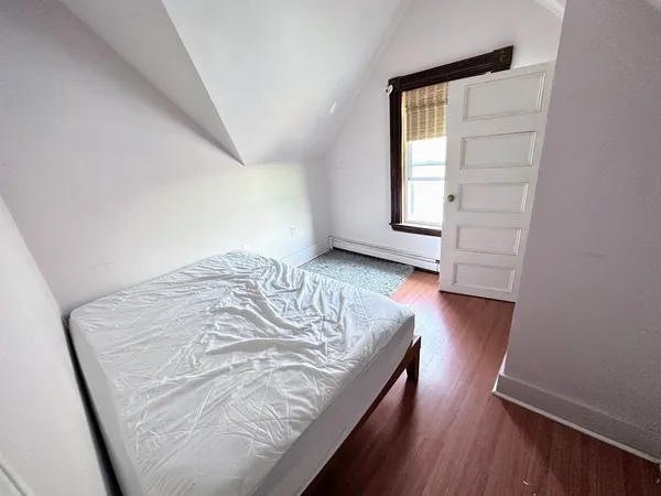 a view of a bedroom with wooden floor