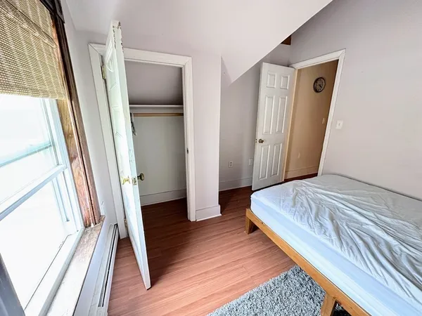 a bedroom with a bed and a large mirror on the dresser