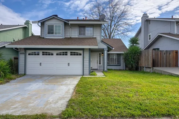 a front view of a house with a garden and yard