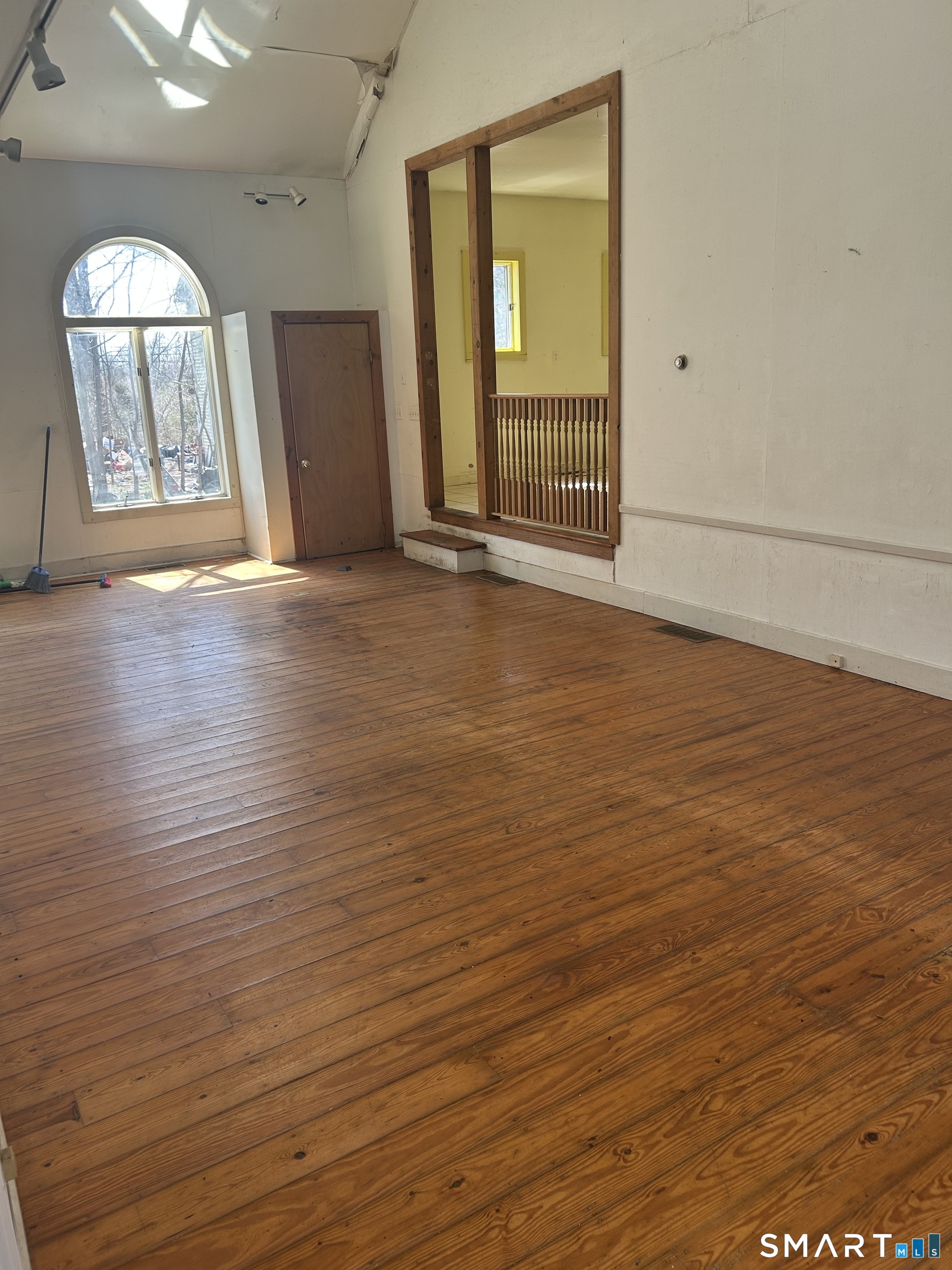 134 Sillimanville Road East Haddam, CT 06469 - Photo 25 of 27 an empty room with wooden floor and mirror