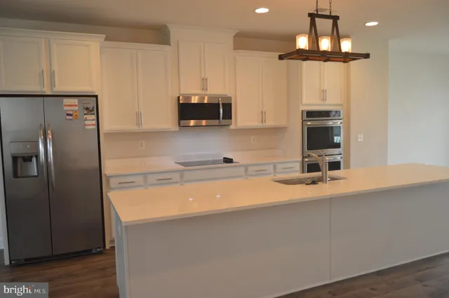 a kitchen with stainless steel appliances a microwave a sink and a refrigerator