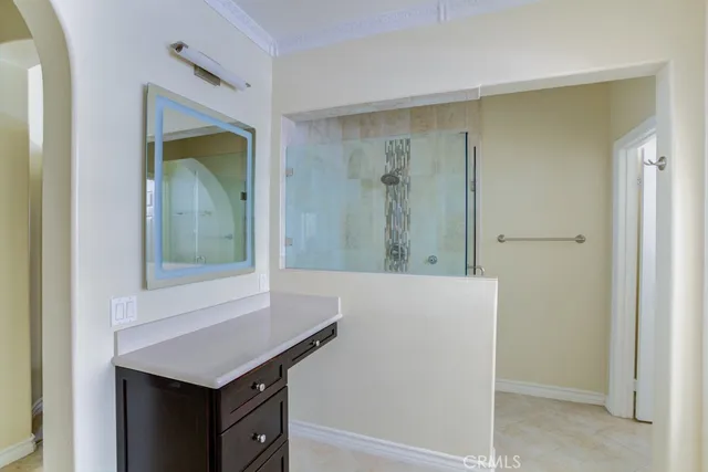 a bathroom with a granite countertop sink a mirror and a shower