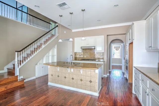 a kitchen with stainless steel appliances granite countertop a sink stove cabinets and refrigerator