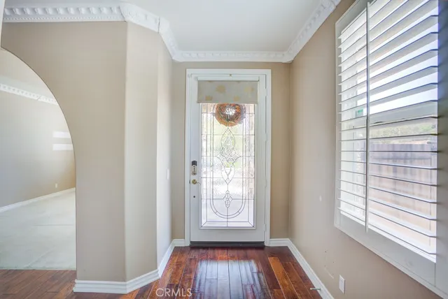 a view of hallway with a window and wooden floor
