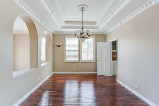 a view of a room with wooden flooring and chandelier